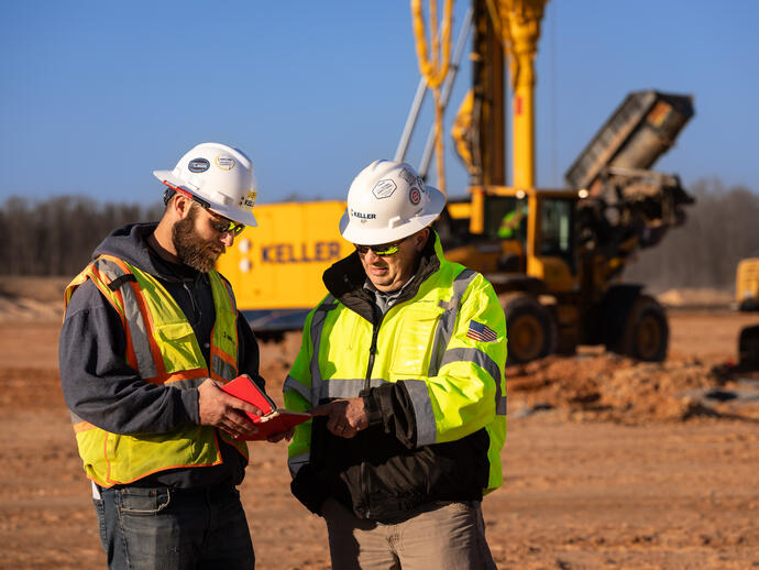 Two construction workers discussing a project on site
